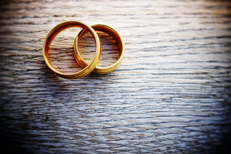 Close-Up Of Wedding Rings On Table